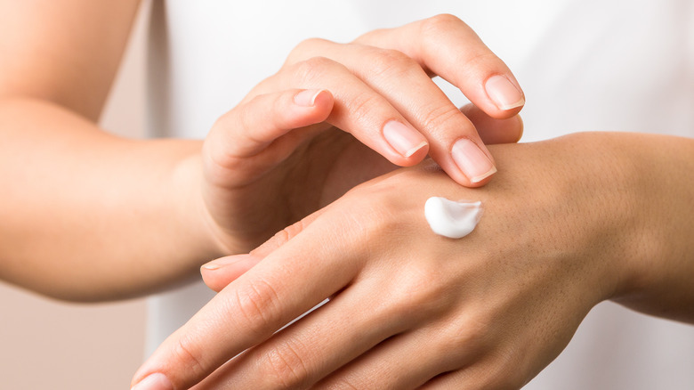 woman applying lotion on hand