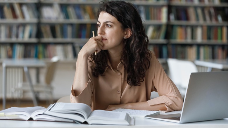 Woman thinking over books