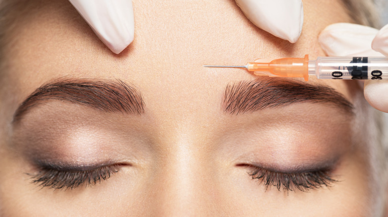 Close up of provider injecting syringe of Botox on patient