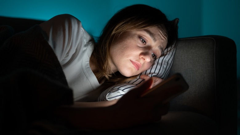 Unhappy woman looks at phone