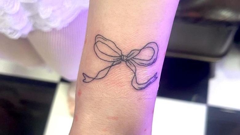 Woman's wrist with bow tattoo