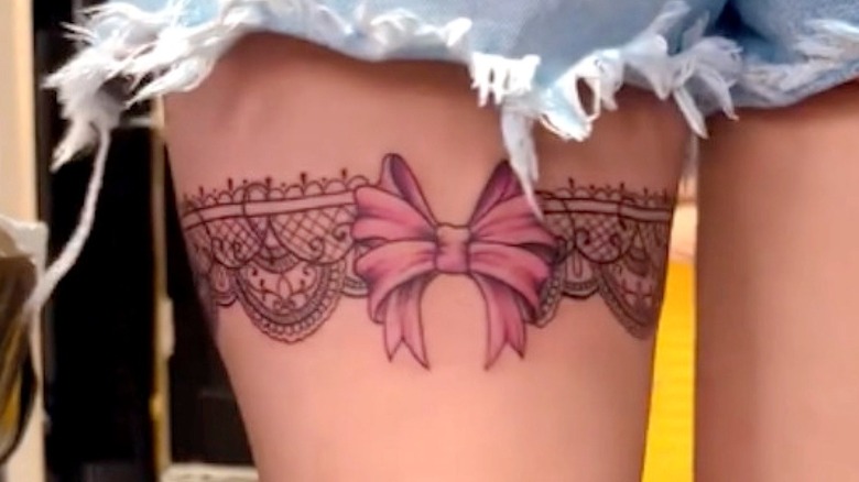 Lace garter tattoo on woman's thigh