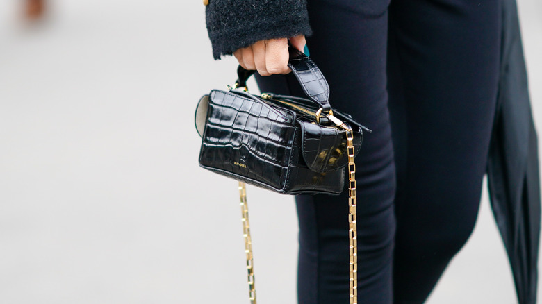 Girl carrying a vanity case on a chain