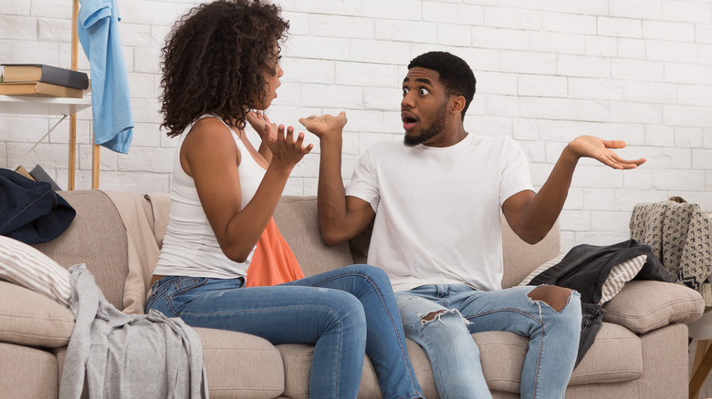 couple arguing on messy couch
