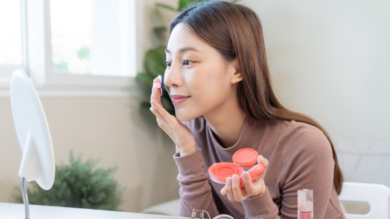 Woman applying blush