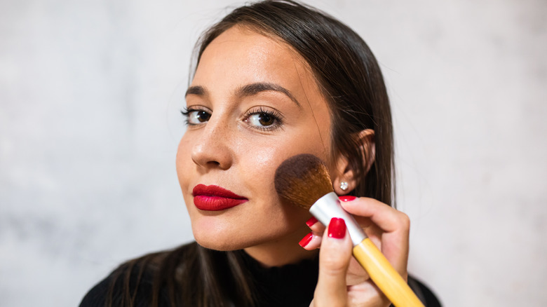 Woman applying blush