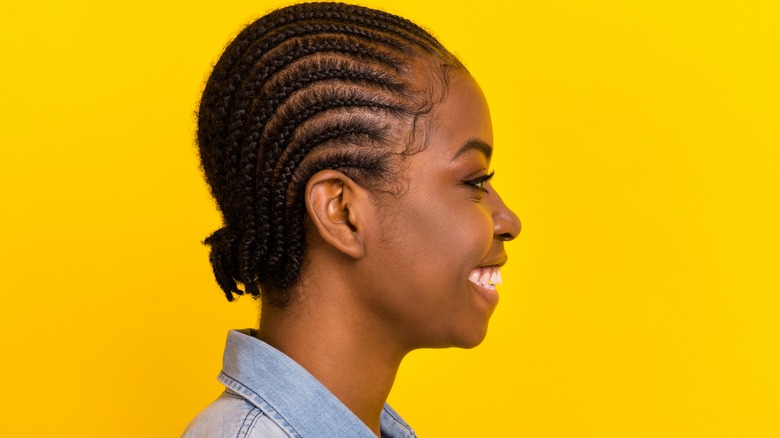 smiling person with cornrows