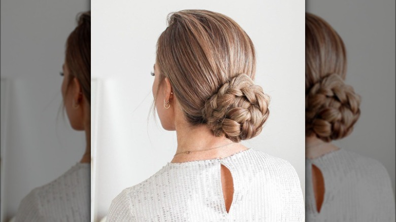 A woman with a low braided bun