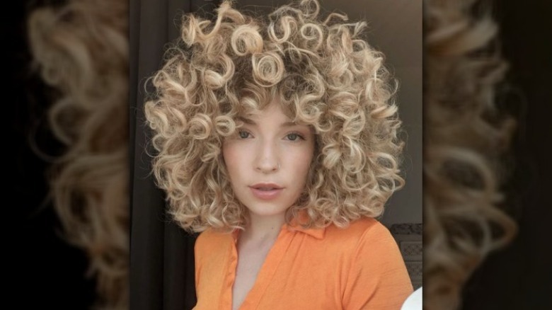 A woman with curly highlighted hair