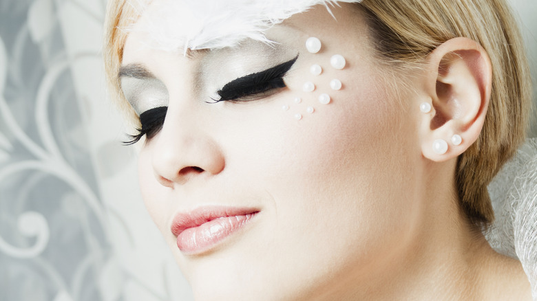 Avant-garde makeup with pearls and feathers