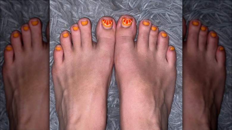 woman with an orange design on her toes
