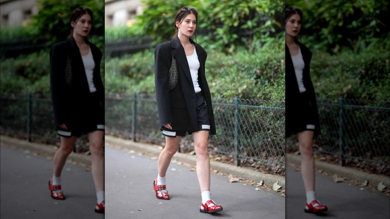 Woman wearing black blazer and red shoes
