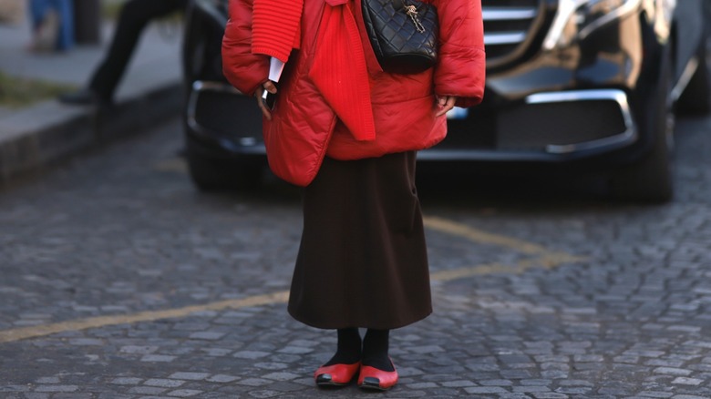 Woman wearing puffer coat and red flats