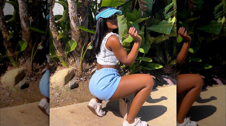 woman wearing blue sweat shorts and visor