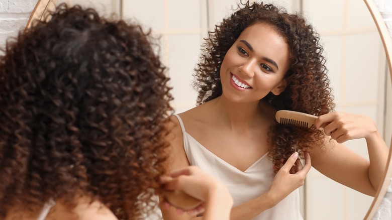 woman brushing her curly hair