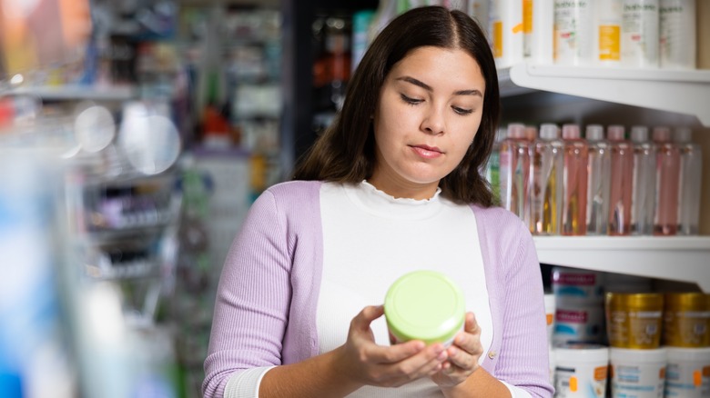 Woman reading skincare ingredients