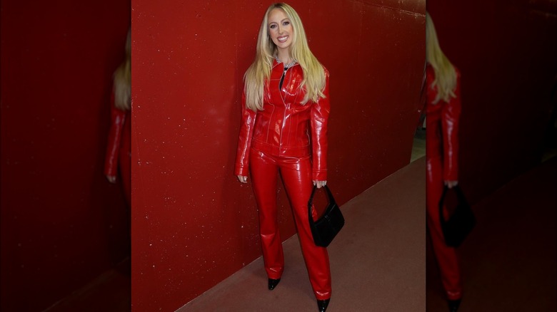 Brittany Mahomes posing in a red latex look.