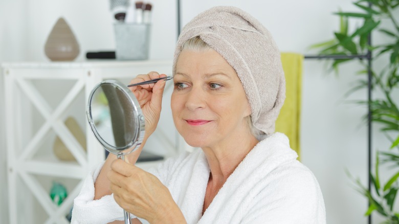 Woman plucking eyebrows