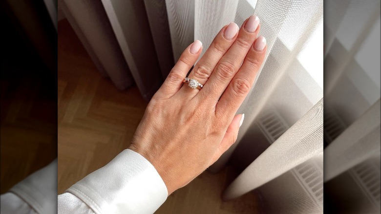Hand with sheer pinky-white nails