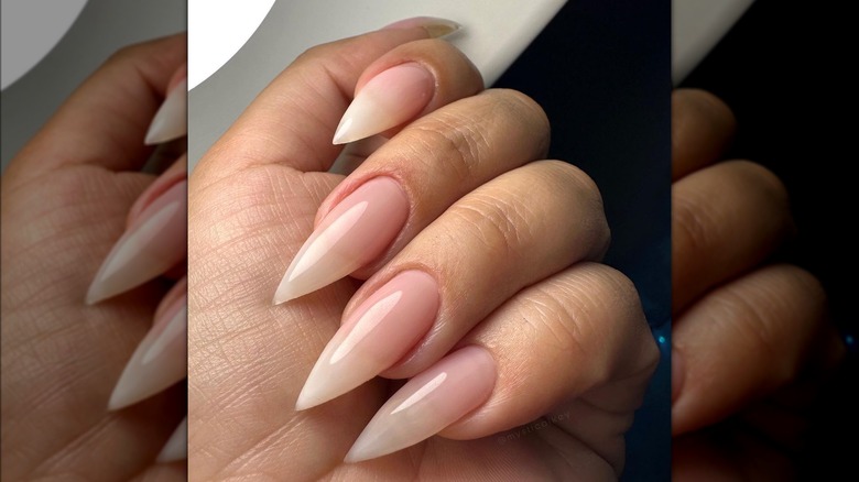 Hand with pink sheer stiletto nails