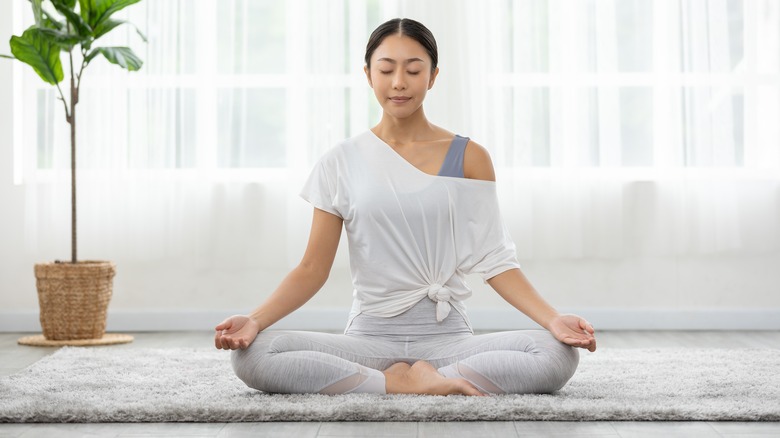 woman meditating on yoga mat