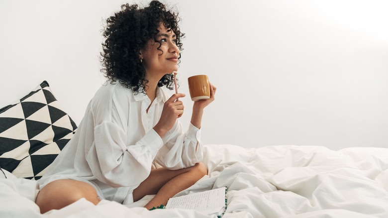 woman in bed drinking tea