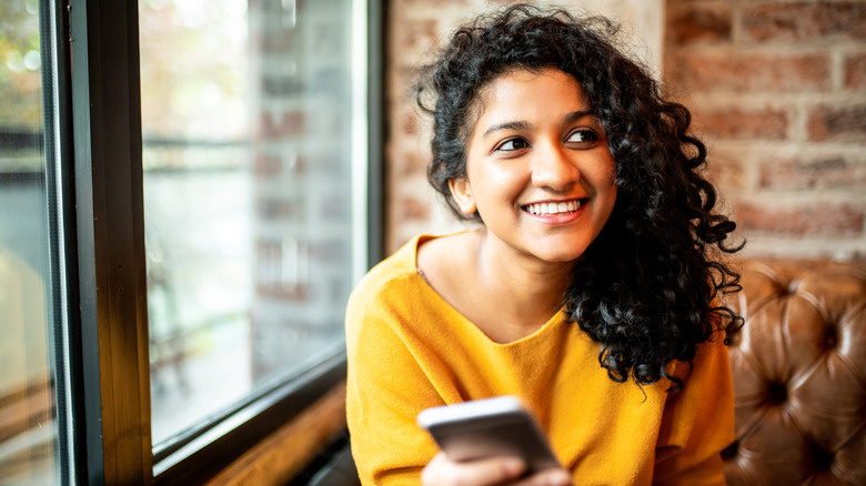 smiling woman holding phone