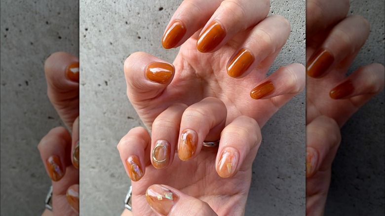 Dark caramel colored marble nails with silver moon