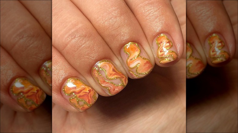 Nude nails with wavy orange and gold design