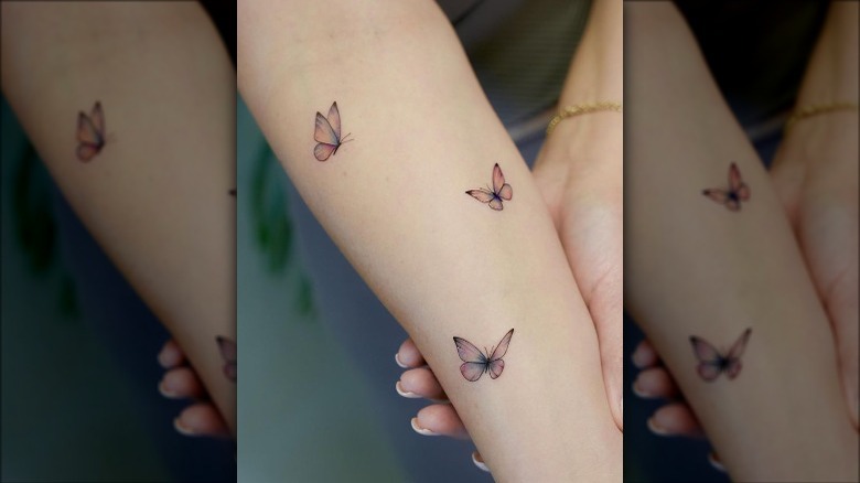 Three small butterflies tattooed on arm