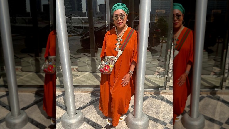Woman poses in orange caftan