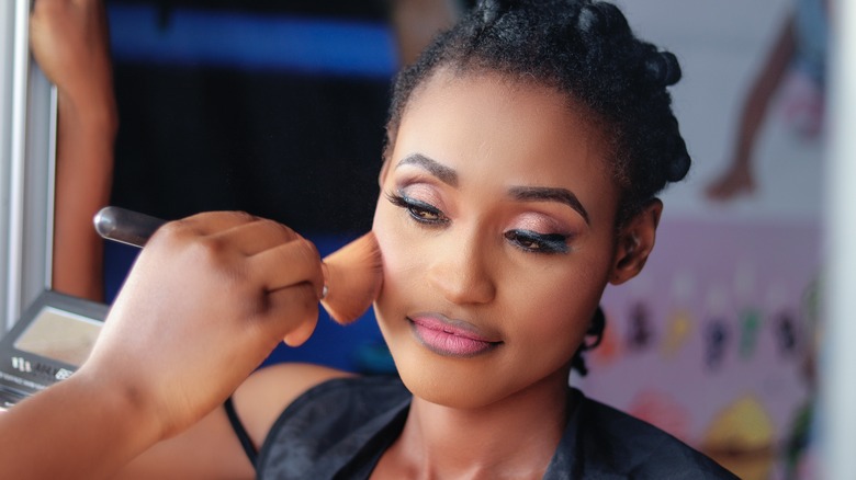 Woman using blush on face