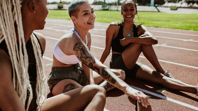 Three women sitting and stretching, smiling