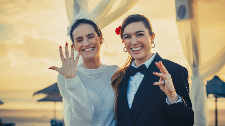 smiling married couple showing rings