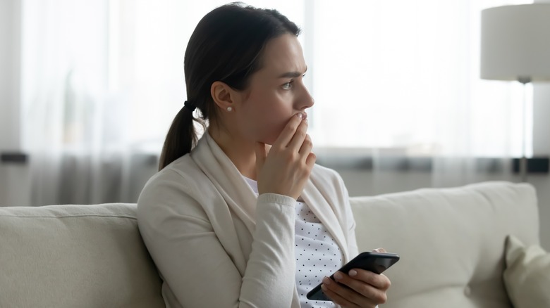 Woman sitting anxiously on a couch.