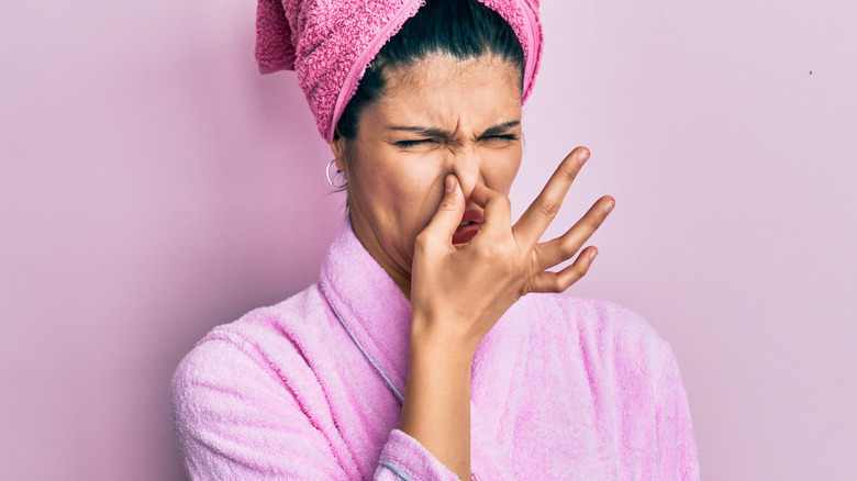 woman plugging her nose