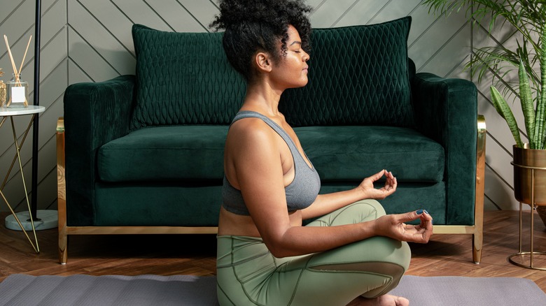 Black woman meditating in house