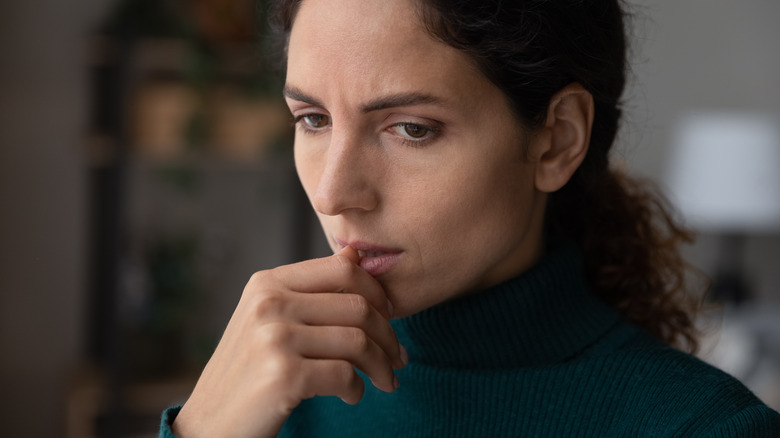 Woman biting nails while thinking