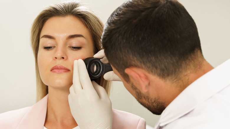 Doctor examining woman's face