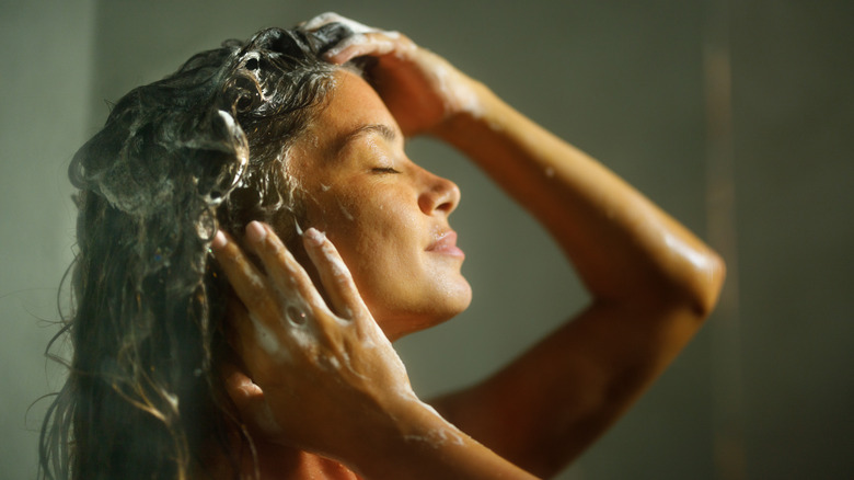 Woman massaging scalp in shower