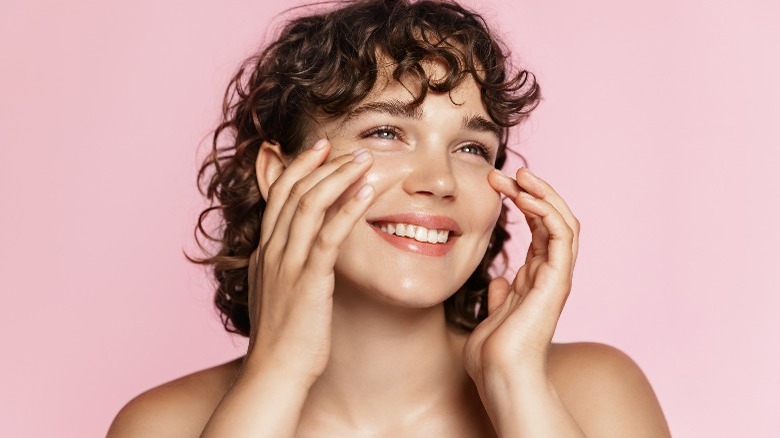 Woman smiling touching her cheeks