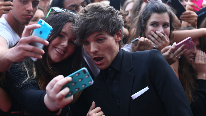 fan taking photo with Louis Tomlinson