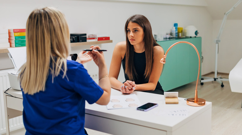 woman talking to plastic surgeon