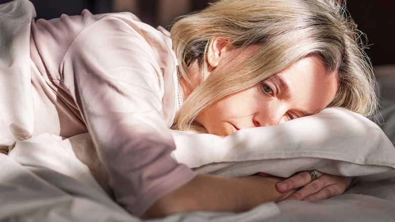 female lying on bed depressed