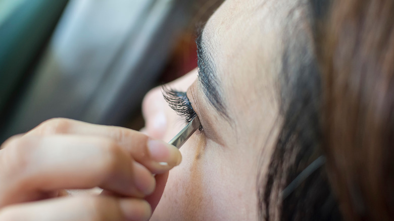 woman installing eyelash extension 