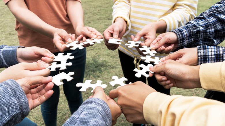 A group holds puzzle pieces