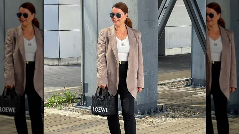 Woman wearing a blazer with a raffia purse.