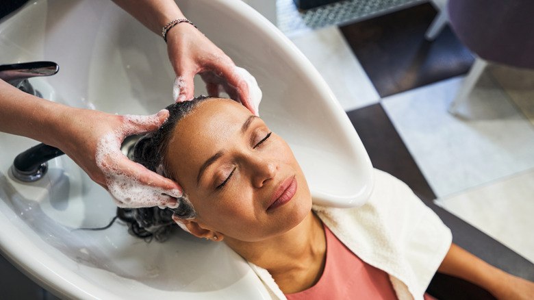 woman getting hair washed at salon