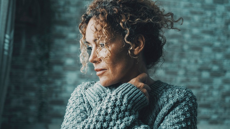 Woman looking sad hugging herself