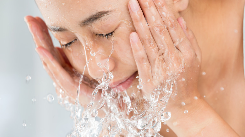 female washing her face